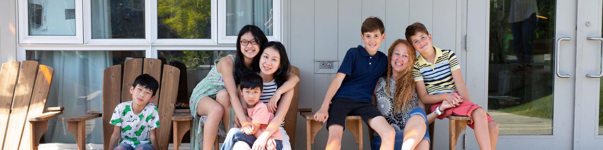 Single mothers with their children sitting on a couch together at YWCA Cause We Care House